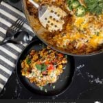 Mexican ground beef with rice with a serving on a dark plate.