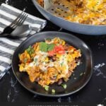 Mexican ground beef with rice with a serving on a dark plate.