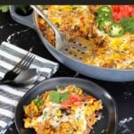 Mexican ground beef with rice with a serving on a dark plate.