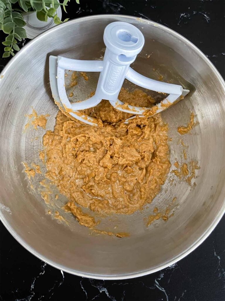 Wet ingredients for oatmeal fudge bars mixed in a metal mixing bowl.