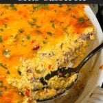 Sausage and cheese grits casserole in a white baking dish with a portion served.