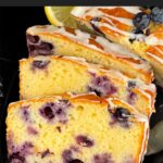 Sliced blueberry bread on a dark platter on a dark surface.