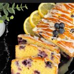 Sliced blueberry bread on a dark platter on a dark surface.