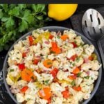 Marinated cauliflower salad in a dark bowl on a dark surface.