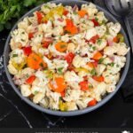 Marinated cauliflower salad in a dark bowl on a dark surface.