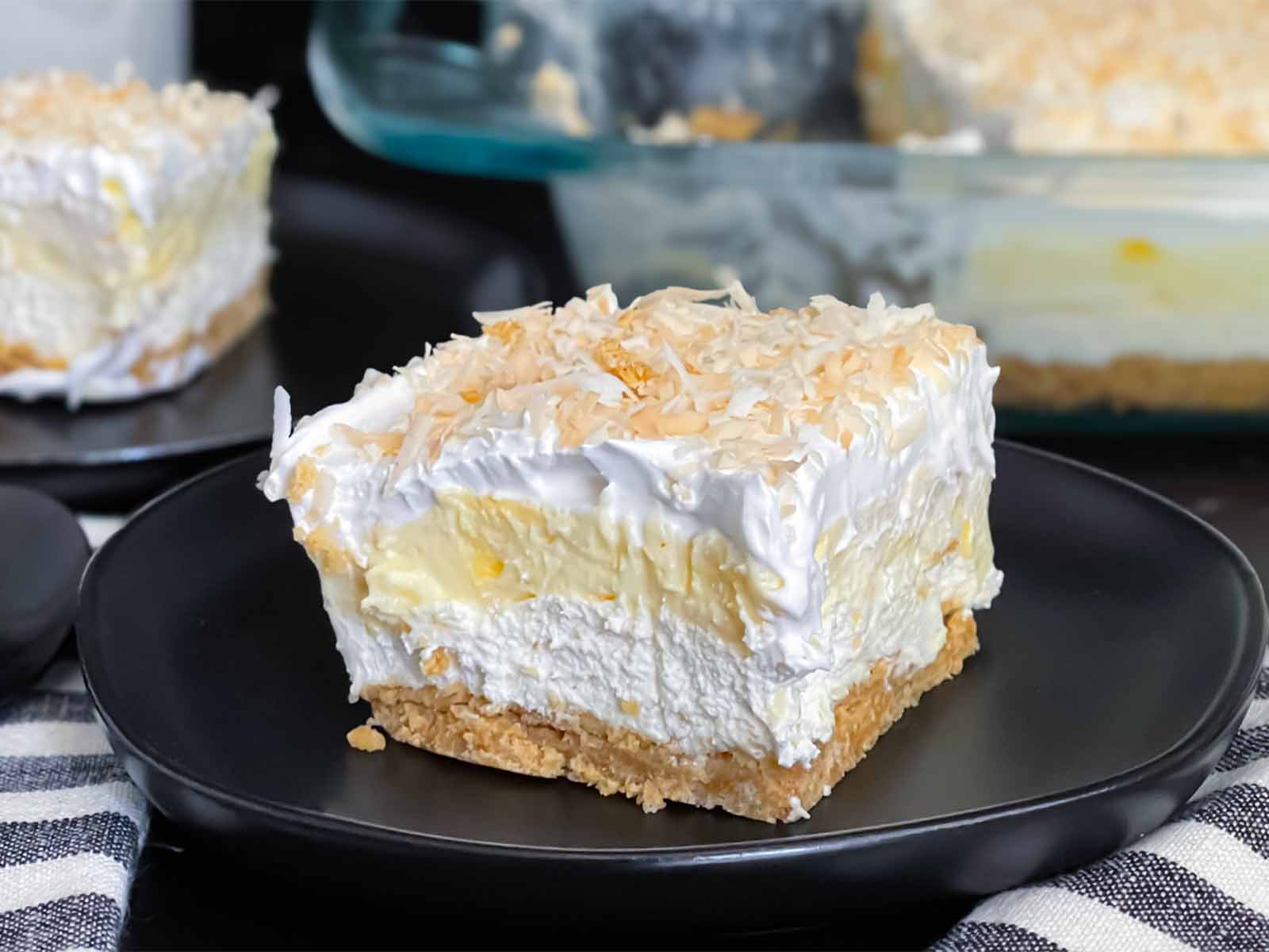 A serving of coconut cream lush on a dark round plate.