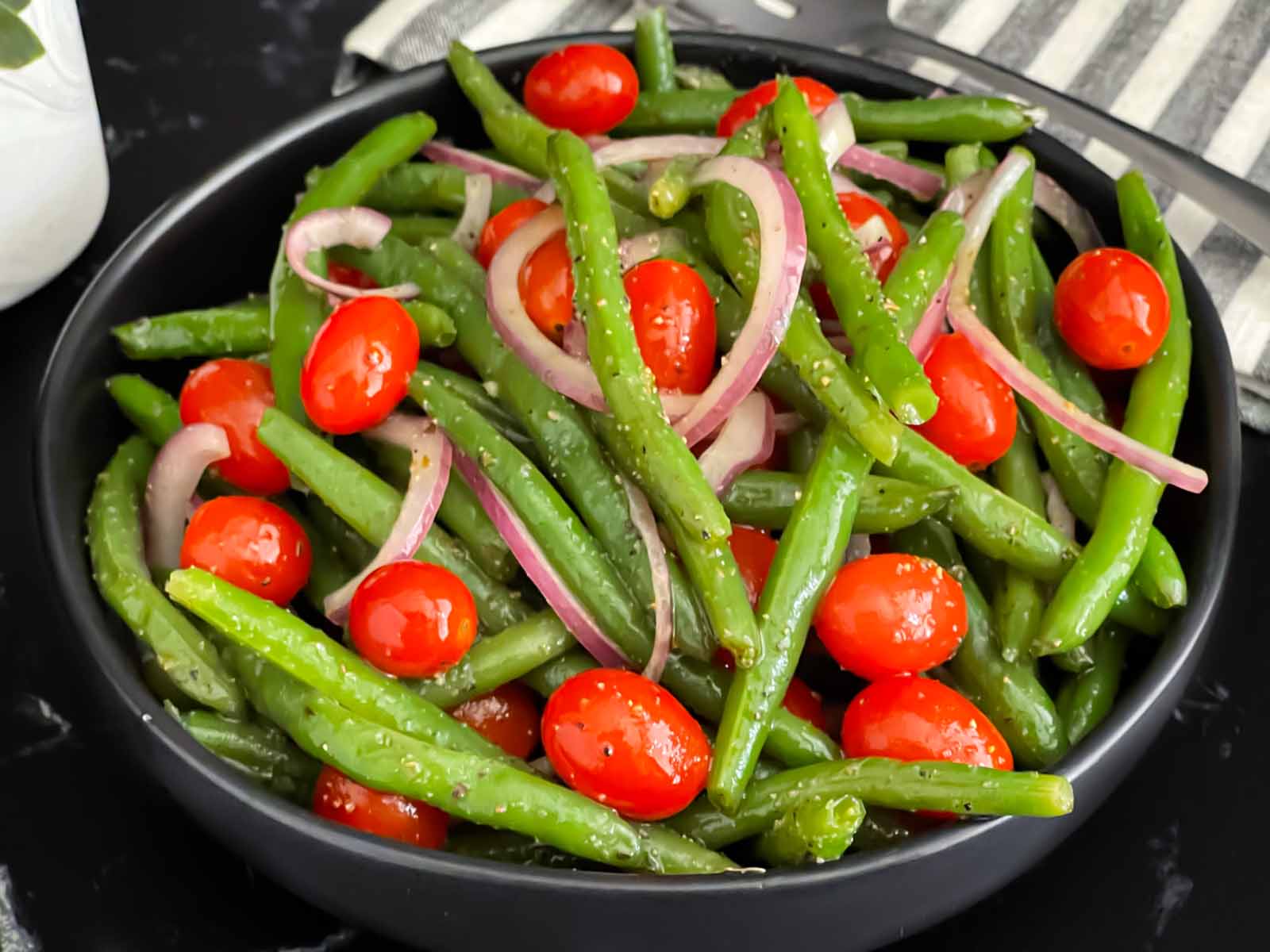 Italian green bean salad in a dark round serving bowl.
