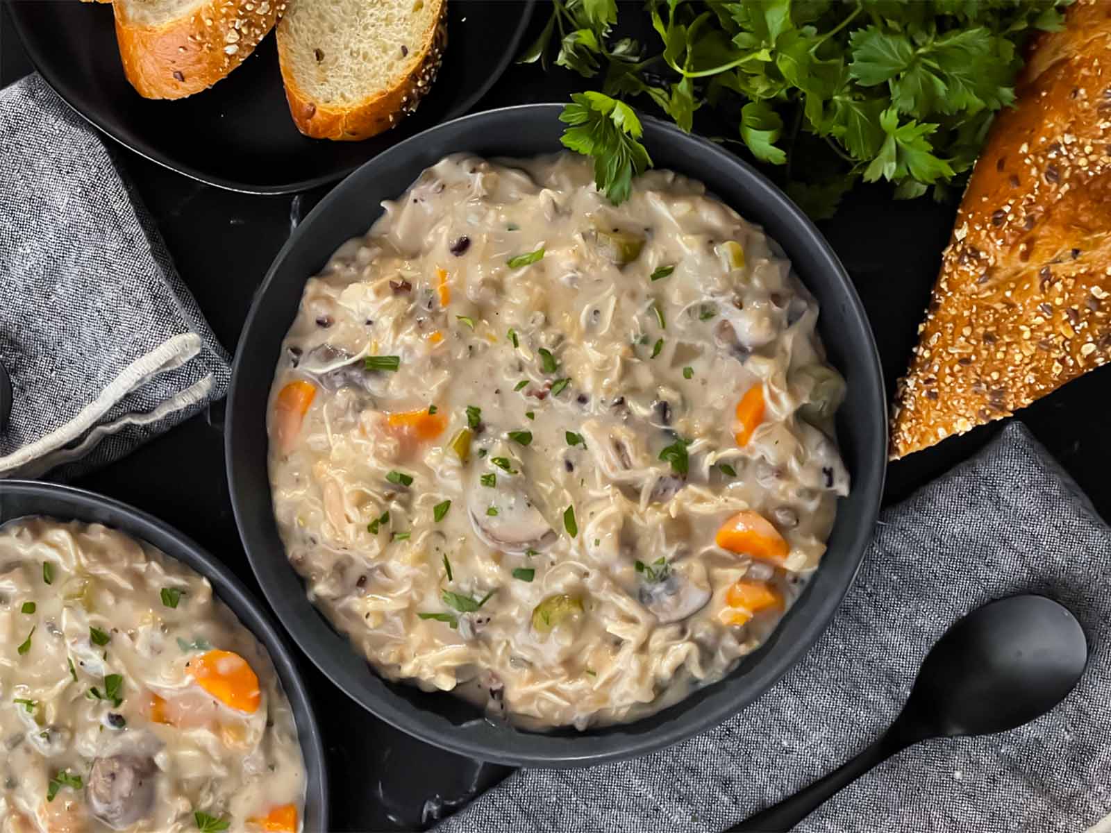 Slow cooker chicken and wild rice soup in a dark bowl.