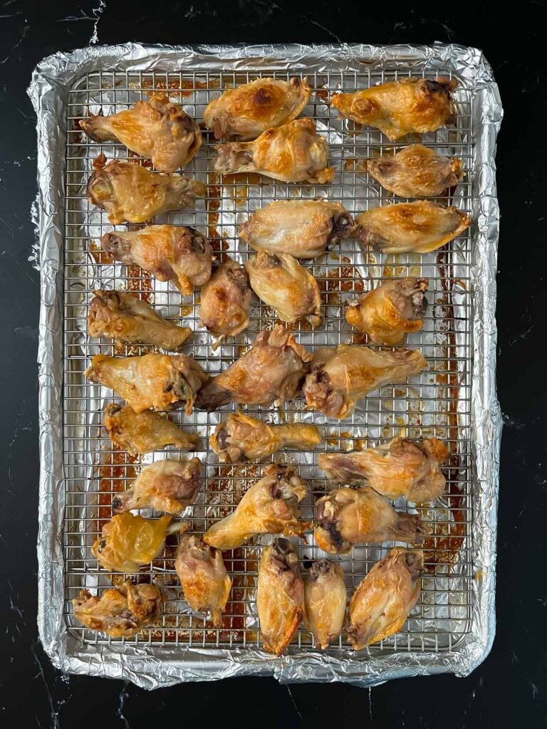 Baked chicken wings on a wire rack.