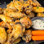 Garlic Parmesan chicken wings on a dark plate.