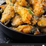 Garlic Parmesan chicken wings on a dark bowl.
