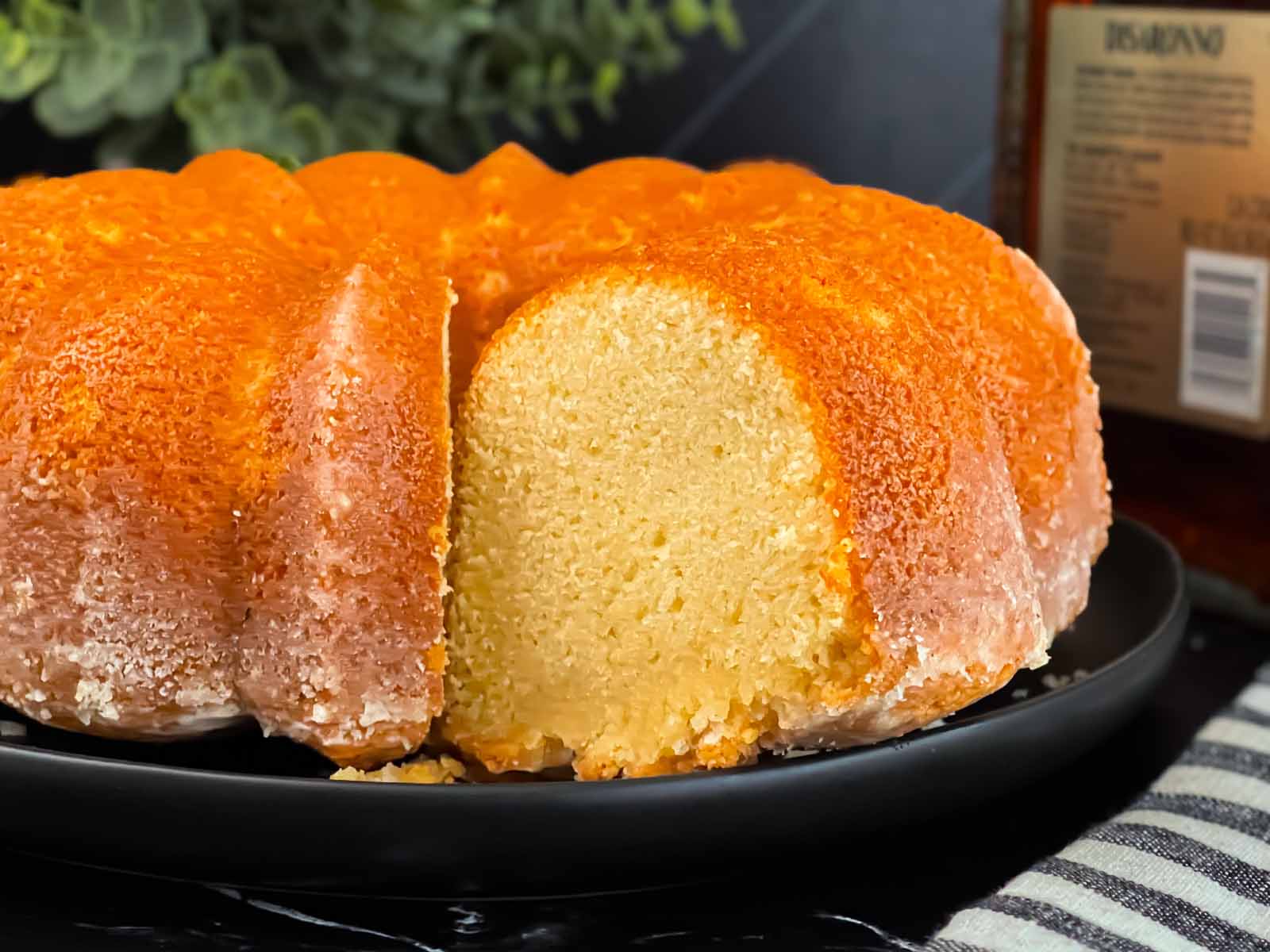 Amaretto pound cake on a dark round platter.