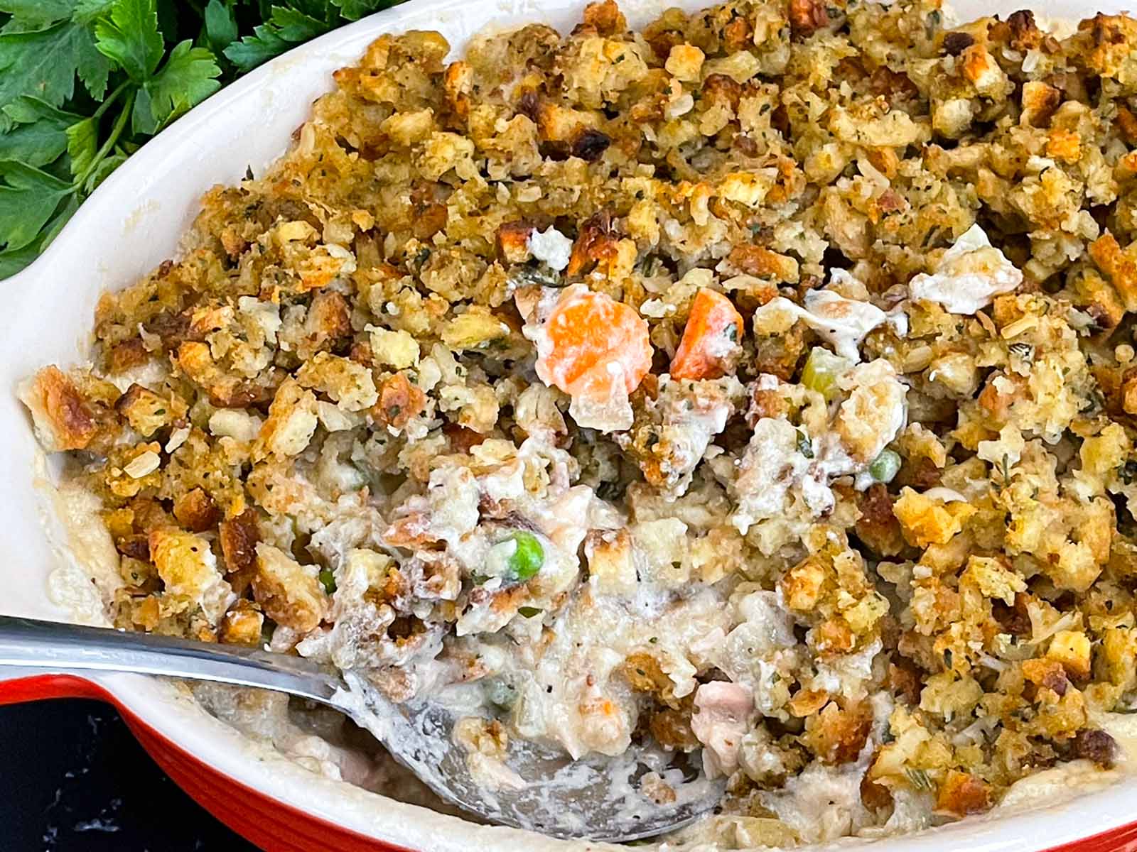 A spoon sitting in the chicken stuffing casserole.