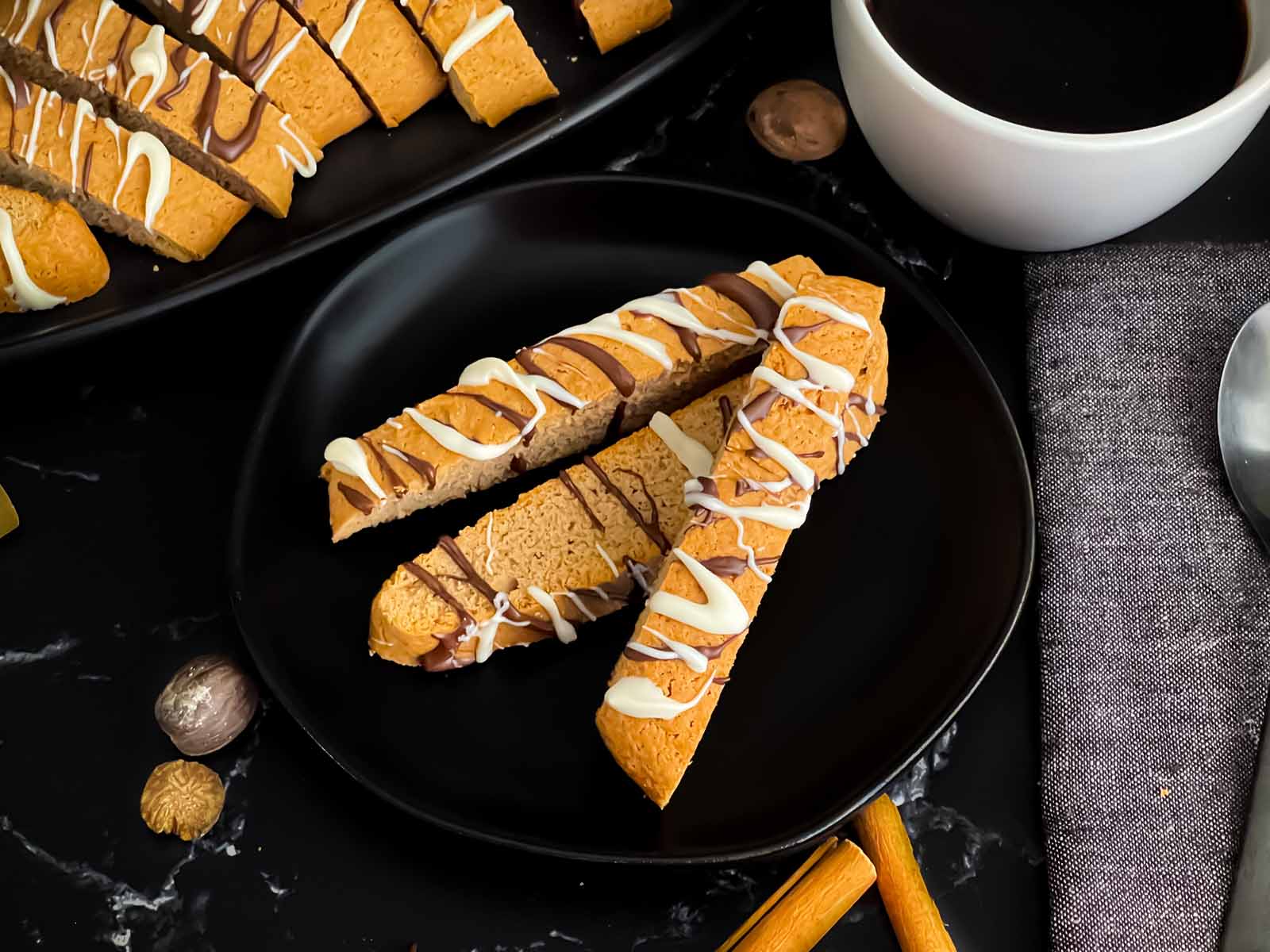 Chai biscotti stacked on a round dark plate.