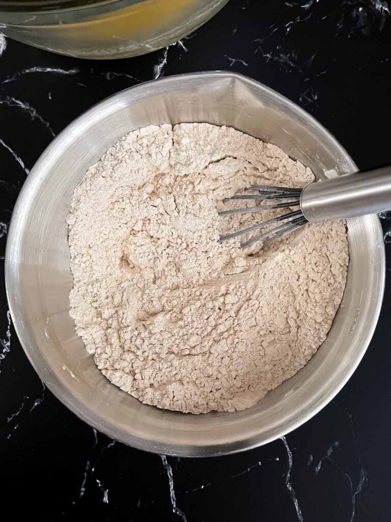 Dry ingredients being mixed in a stainless steel bowl.