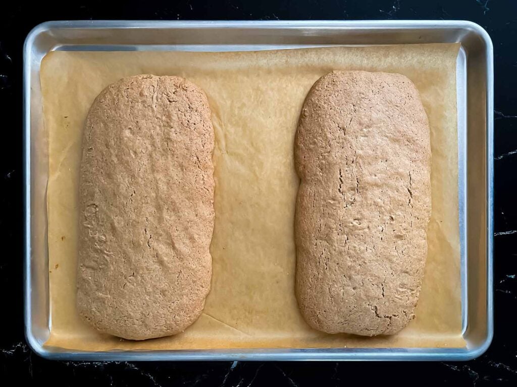 Baked chai biscotti loaves on a baking sheet.