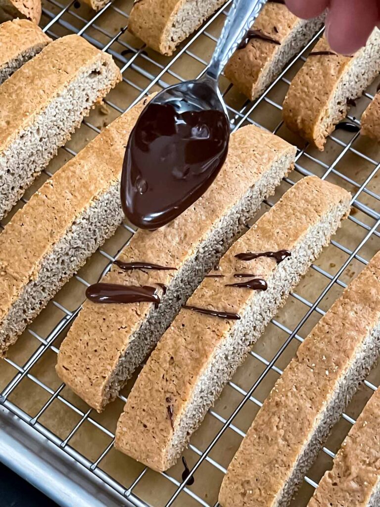 Adding a chocolate drizzle to the chai biscotti.