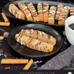 Chai biscotti on a dark plate with coffee.