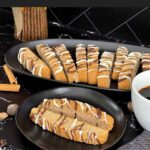 Chai biscotti on a dark plate with coffee.