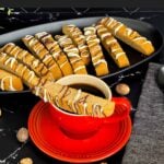 Chai biscotti on a dark plate with coffee.