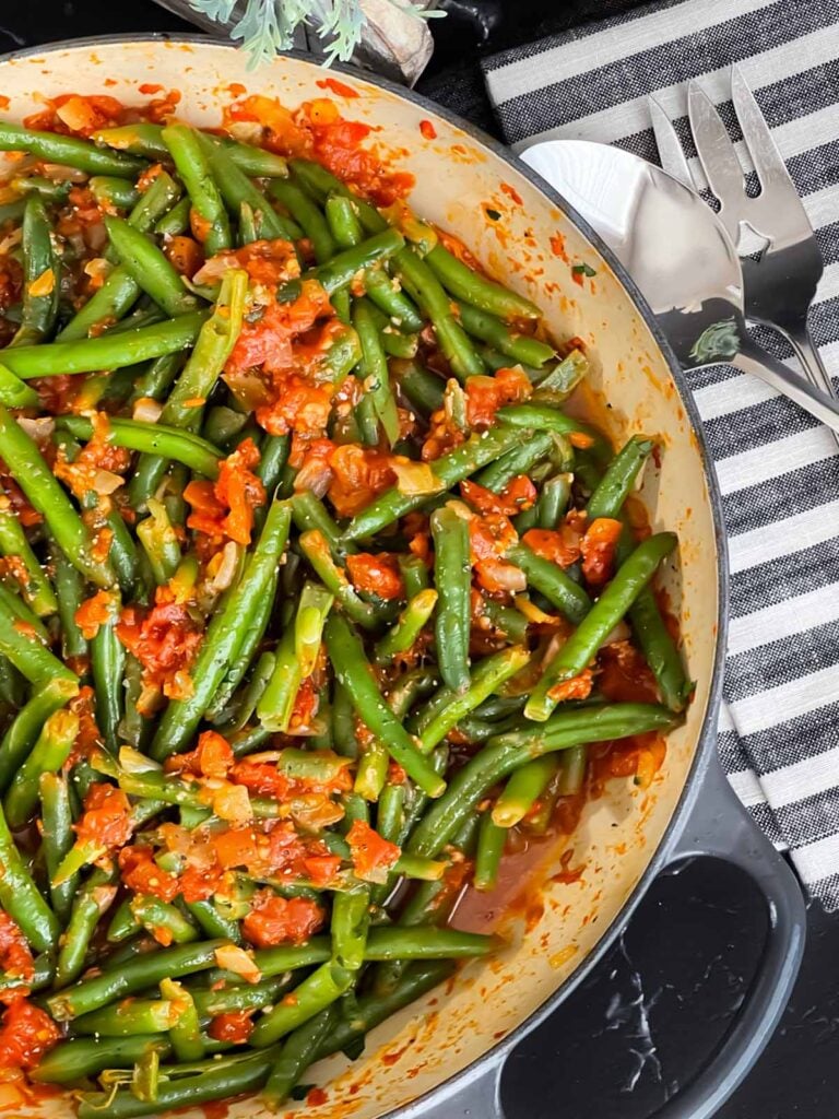 Green beans with tomato sauce in a large skillet.