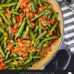 Green beans with tomato sauce in a dark bowl.