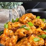 Bang Bang Chicken in a dark bowl, garnished with green onion.
