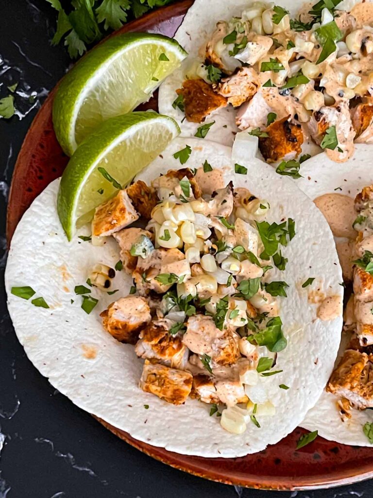 Southwest grilled chicken tacos on a red plate.