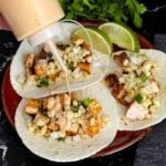 Adding a southwest sauce to grilled chicken tacos.
