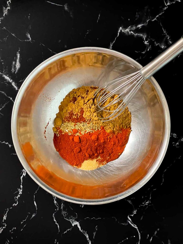 Southwest spices in a stainless steel bowl, unmixed.