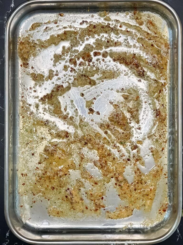 Melted butter and spices in a large baking dish.