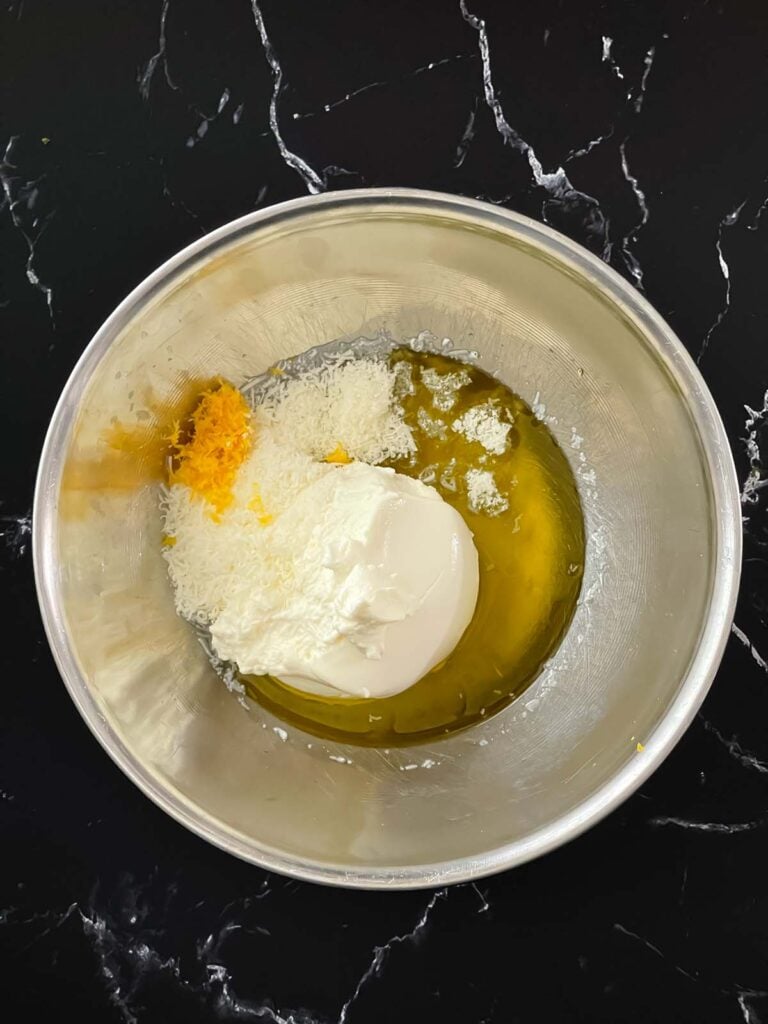 Lemon ricotta sauce ingredients in a stainless steel bowl.