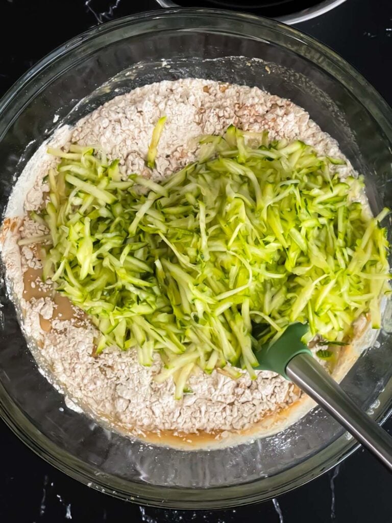 Adding zucchini to the muffin ingredients.