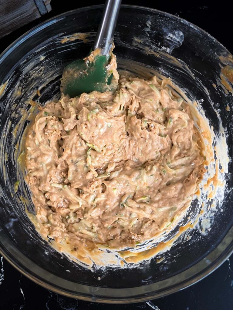 Zucchini muffin mix in a large glass bowl.
