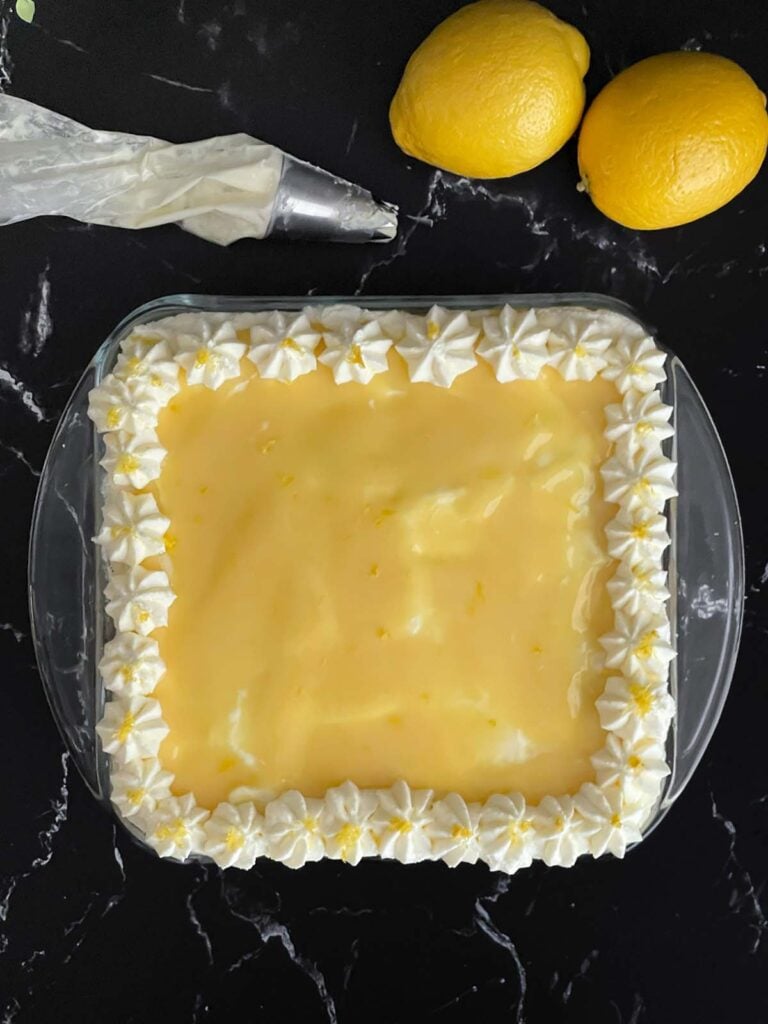 Limoncello tiramisu decorated with whipped mascarpone stars in a glass baking dish.