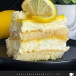 Limoncello tiramisu serving on a dark plate on a dark surface.