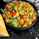 Shrimp and corn salad in a dark bowl.