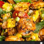 Shrimp and corn salad in a dark bowl.