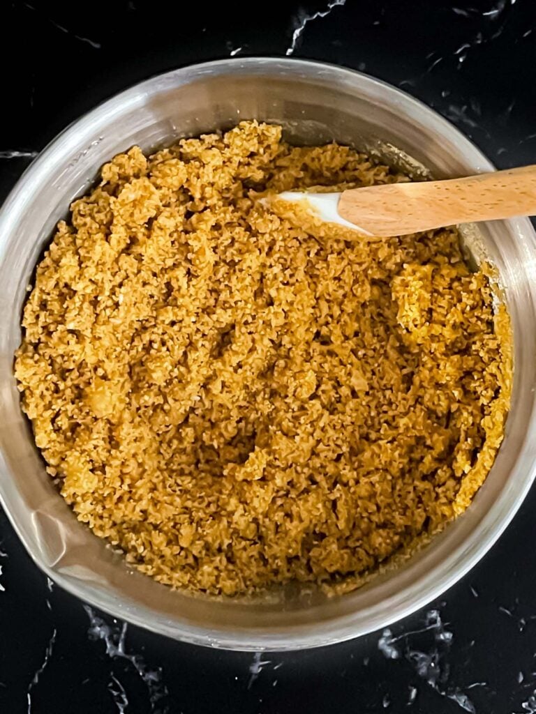 A graham cracker crust mixed up in a metal bowl.