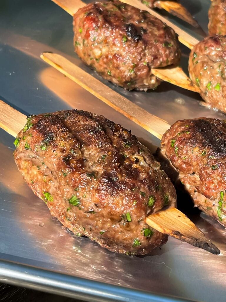 Grilled kofte on a baking pan.