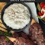 Spiced beef kebabs (kofte) with pita, tzatziki sauce, and a tomato cucumber salad.