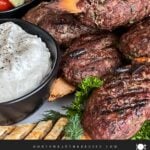 Spiced beef kebabs (kofte) with pita, tzatziki sauce, and a tomato cucumber salad.