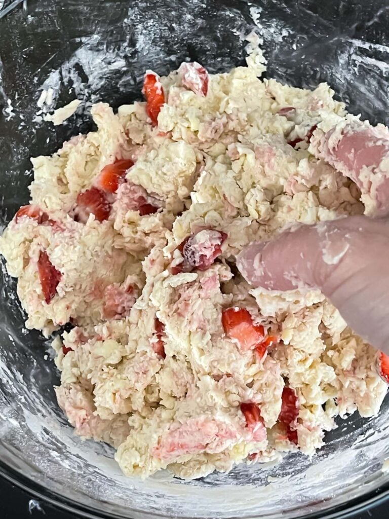 Mixing strawberry scone dough by hand.