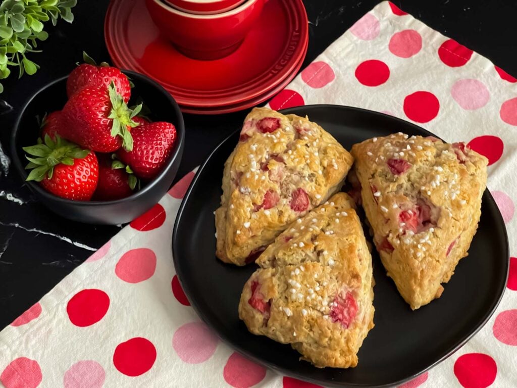 Strawberry scones on a dark plate.