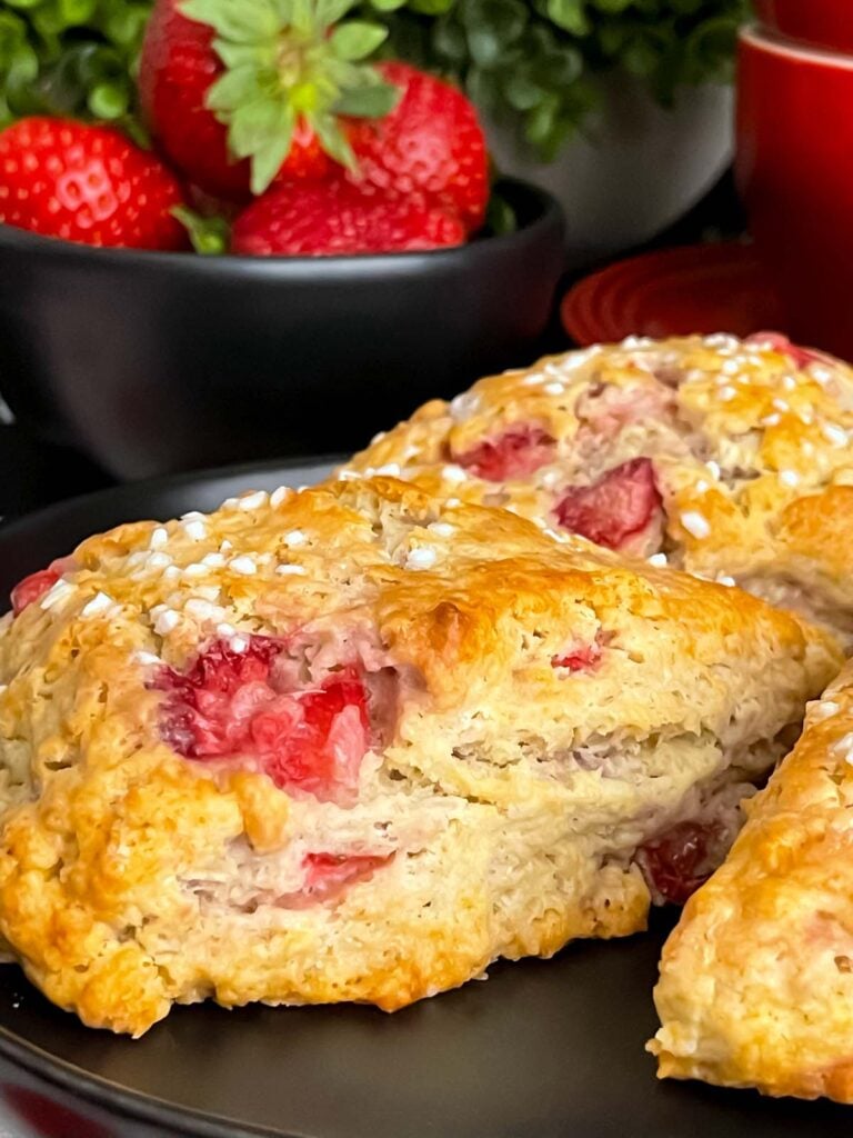Strawberry scones on a dark plate.