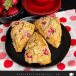 Strawberry scones on a dark plate.