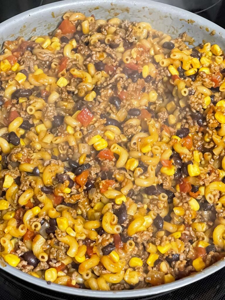 Taco pasta skillet cooking in a skillet.