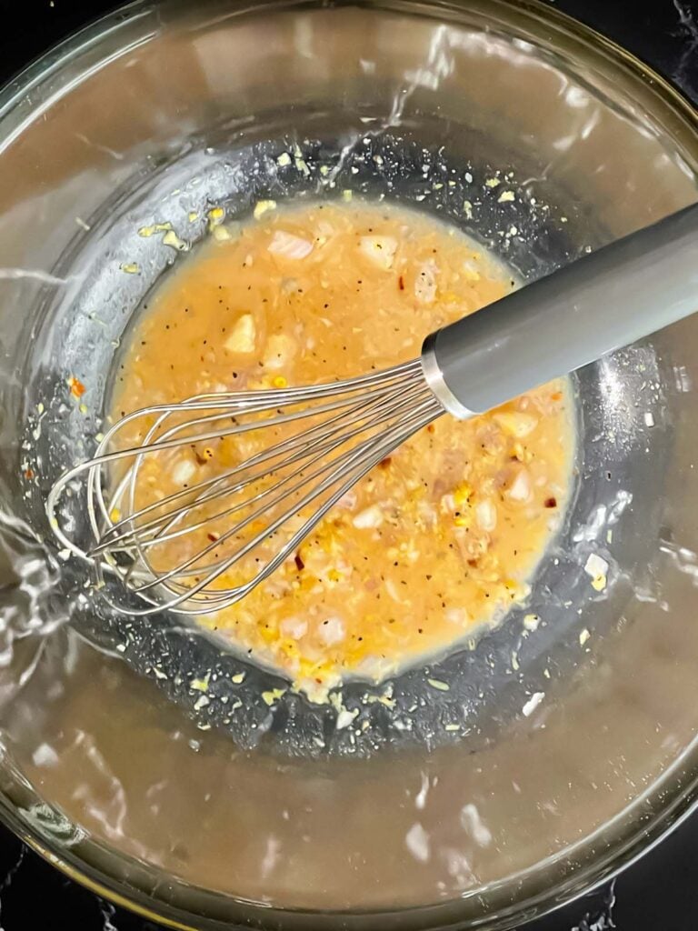 Dressing ingredients in a glass bowl.
