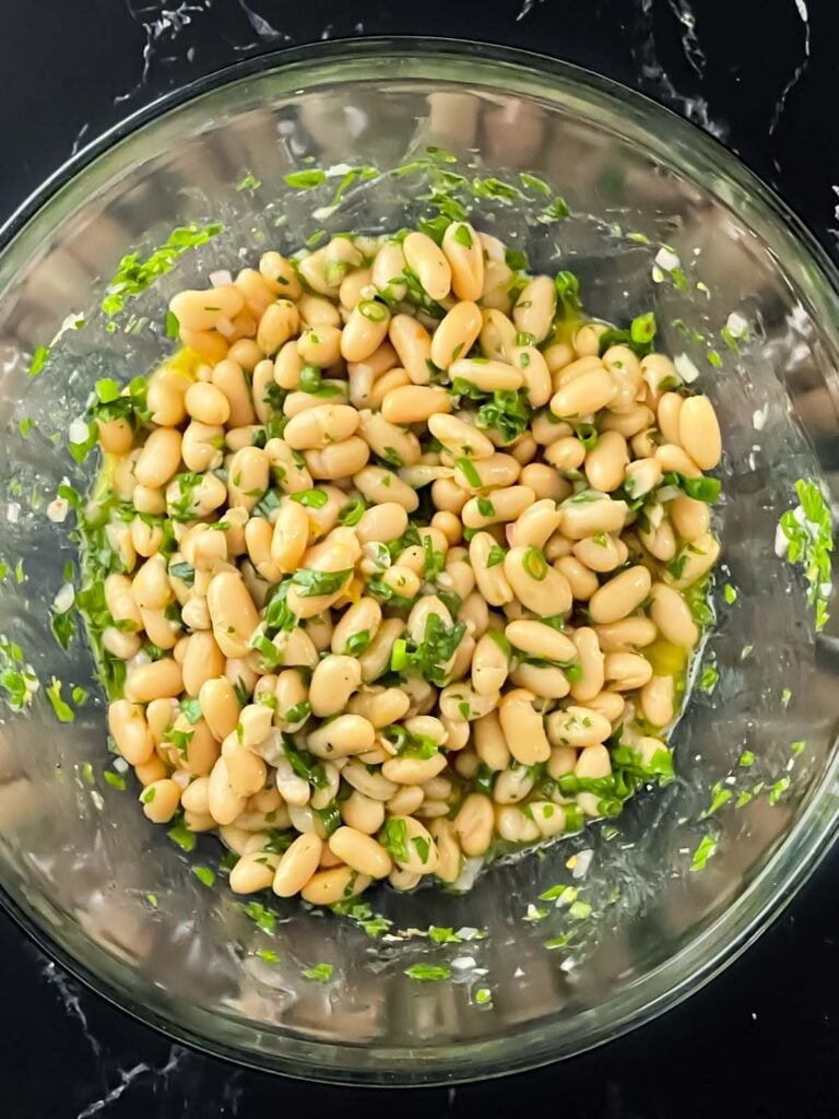 Lemon White Bean Salad mixed up in a glass bowl.