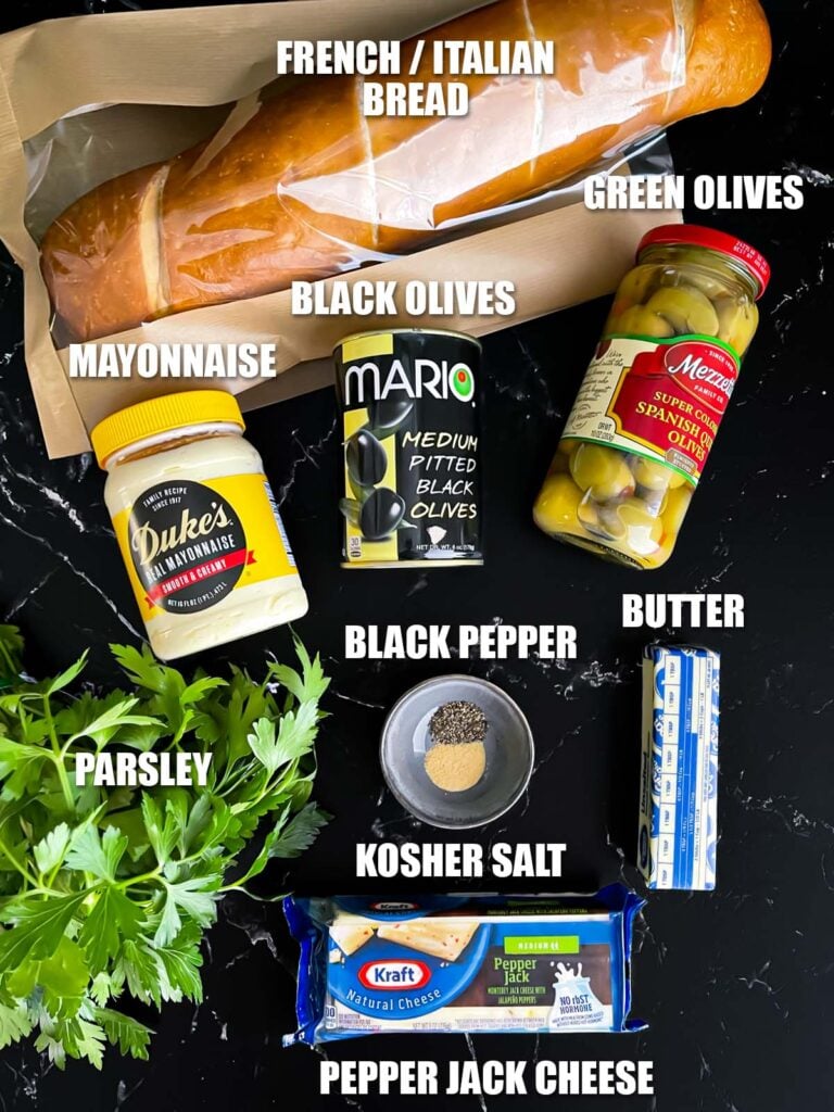 Olive cheese bread recipe ingredients on a dark surface.